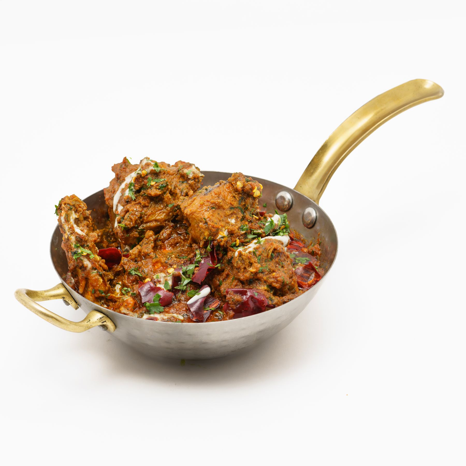 Spiced chicken curry in a brass pan
